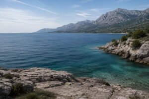 Felsige Mittelmeerküste mit blauem Meer und Gebirgen als sichtbare Überreste von Greater Adria.