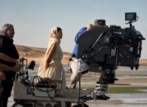 Große IMAX-Filmkamera auf einem Kamerawagen während der Dreharbeiten zu „The Odyssey“ in einer Küstenlandschaft.